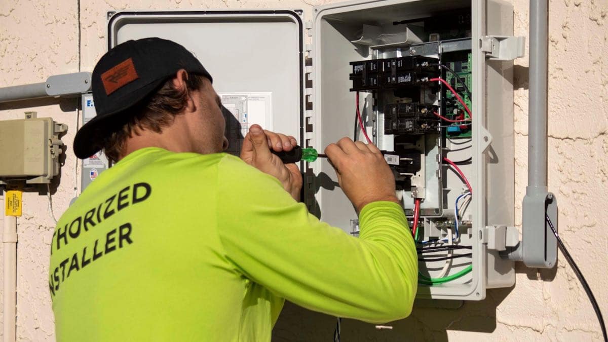 Un electricista trabajando en un panel eléctrico abierto